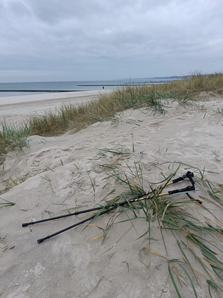 Kije do nordic walking na plaży w Ustce oparte na falochronie. Najlepsza aktywność nad morzem jesienią.