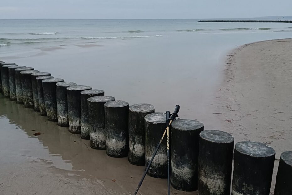 Kije do nordic walking na plaży w Ustce oparte na falochronie. Najlepsza aktywność nad morzem jesienią.